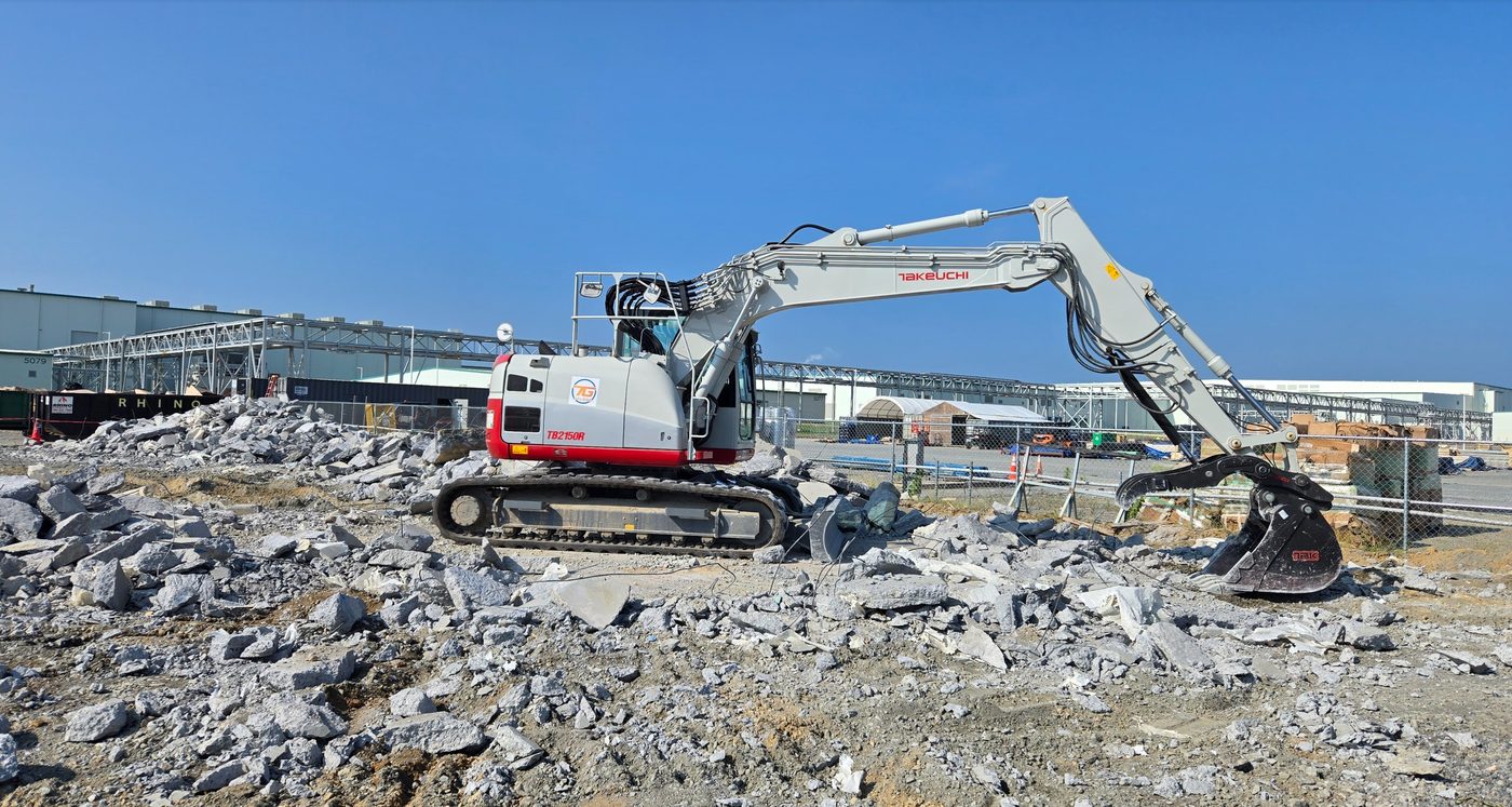 Excavator demolishing a structure and breaking concrete